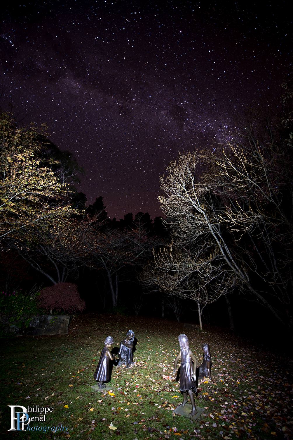 Children bronze sculptures and milky way